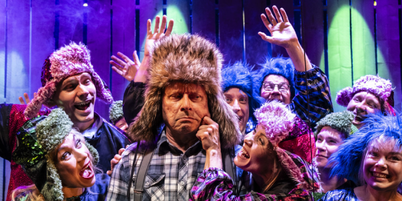 Kuva Mielensäpahoittaja-mussikaalista. Nainen nipistää karvalakkipäistä miestä poskesta. 