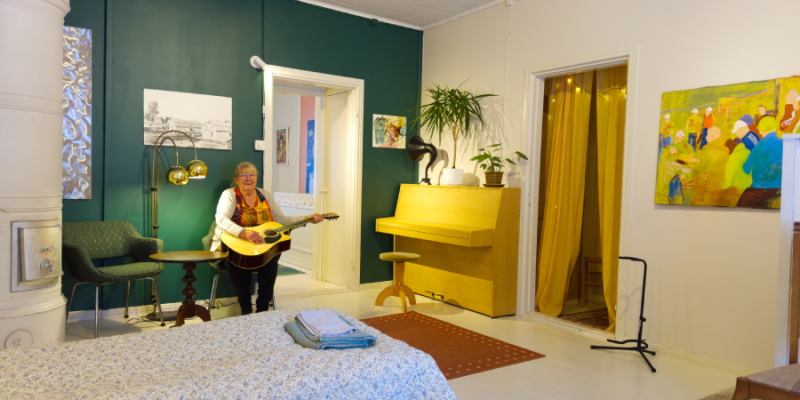 Nainen istuu sohvalla Taideniityn huoneistossa