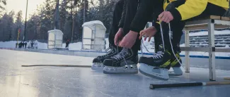 Luistimien nauhojen kiinni laittoa jäällä.