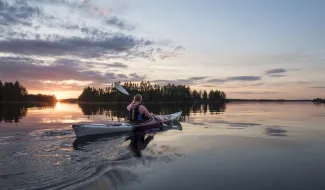 Nainen meloo kanootissa