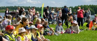 lapsia ja aikuisia nurmella