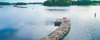 Kolme naista istuu Taipaleen vanhan kanavan reunalla