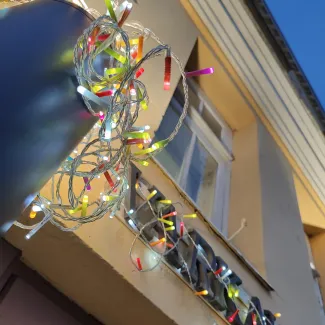 värikkäitä ulkovaloja keltaisen talon seinustalla lähikuvassa.