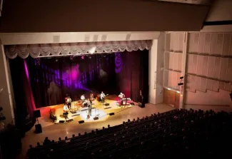 Warkaus-Salin auditorio kuvattuna katsomosta päin, lavalla esiintyjiä