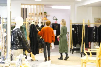 Kaksi naista myymälässä selin kameraan