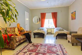 Nainen istuu sohvalla Taideniityn huoneistossa