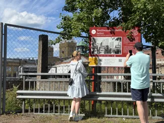 Nainen ja mies selin kameraan Vanha Varkaus -elämyskierroksen kyltin äärellä